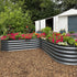 Two metal raised garden beds with flowers in front of a white shed.